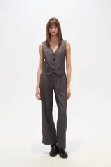 Chaleco de vestir sin mangas, color negro con finas rayas verticales blancas. Presenta escote en V, cierre frontal con botones y bolsillos falsos a la altura de la cintura.