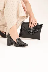 Mocasines negros de cuero brillante con punta cuadrada y taco revestido.