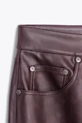 Pantalón de tiro alto color marrón con efecto piel, corte bootcut, cinco bolsillos y cierre frontal con cremallera y botón.