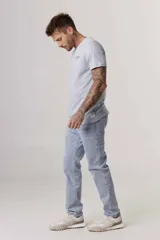 Jeans de corte regular, color celeste, con cinco bolsillos y cierre frontal.
