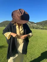 Ruana negra de lana merino con flecos.
