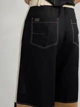 Pantalón ancho de corte recto con fit holgado, de lino color beige con bloques de color negro y marrón.