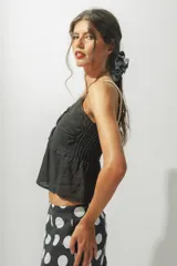 Top blanco con breteles finos y detalle de nudo en el centro del busto.