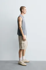 Bermuda cargo de algodón color marrón oscuro, tiro medio, corte regular, con bolsillos laterales de parche con solapa y bolsillos traseros de vivo.