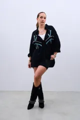 Camisa negra de corte amplio con botones y estampado de líneas con lentejuelas en color celeste y plateado.