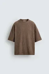 Camiseta marrón de algodón con textura irregular, corte relaxed fit, cuello redondo y manga corta.
