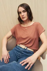 Remera color beige de tejido acanalado, con cuello bote y mangas cortas con dobladillo.