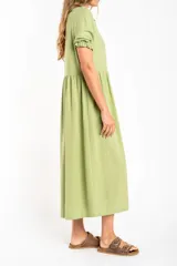 Vestido midi verde claro de lino, con cuello camisero, mangas cortas abullonadas y abotonadura frontal.