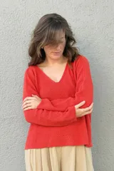 Sweater de punto color naranja con cuello en V y mangas largas.