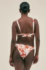 Top de bikini con estampado floral color naranja y blanco, con aro metálico en el centro del busto. Se ata al cuello y en la espalda. Cuenta con almohadillas removibles.