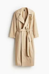 Gabardina larga color beige de corte holgado, con solapas de muesca, mangas raglán, bolsillos laterales y cinturón para atar.