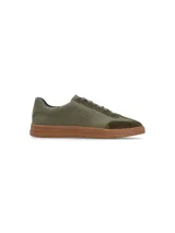 Zapatillas urbanas blancas con detalles en gamuza gris y suela de goma marrón.