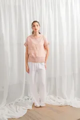 Blusa de lino color rosado, de corte holgado, con cuello redondo y detalle de encaje en ruedo y mangas.