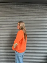 Cárdigan de punto color naranja con parches en los codos.