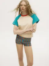 Remera colorblock con mangas ranglan color naranja, cuerpo blanco y cuello amarillo.