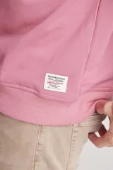 Buzo rosado de corte holgado con cuello redondo y puños y cintura acanalados.