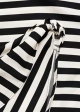 Vestido largo de fiesta con estampado de rayas diagonales en blanco y negro, escote asimétrico de un solo hombro y detalle de nudo en el tirante.