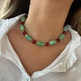 Collar corto con cuentas de piedra verde, cuentas de piedra roja y detalles dorados.