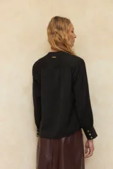 Blusa verde oliva de manga larga con cuello mao y escote en V. Cuenta con triple botón de nácar en los puños.
