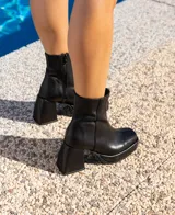 Botas cortas de cuero negro, con cierre lateral, taco de madera forrado en cuero y suela de goma.