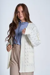 Sacón de hilado frizado color crudo, con calado delicado y bolsillos tejidos al frente. De corte relajado.