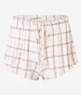 Conjunto de pijama corto compuesto por una remera de algodón blanca con estampado de mascotas y un short de viscosa a cuadros en tonos rosa y beige con volados en el ruedo.