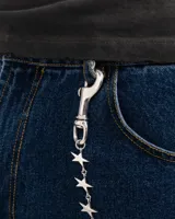 Cadena para pantalón de metal plateado con eslabones en forma de estrellas tridimensionales y cierres de mosquetón en ambos extremos.