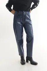 Pantalón de jean azul con estampado de cuadrados plateados.