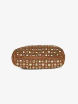 Mini bolso cubo negro con tachuelas doradas, confeccionado en cuero con detalles metálicos. Tiene doble asa corta y cierre con broche magnético.