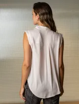 Blusa negra de gasa marca Tahari, con cuello a la base con solapa, abertura central con botones ocultos y detalle plisado en hombros.