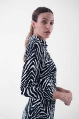 Vestido midi con estampado cebra, corte al cuerpo, cuello camisero y abotonadura frontal.