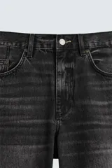 Bermuda de denim de algodón, color gris claro lavado, de corte ancho (baggy fit) y largo hasta la rodilla. Presenta cinco bolsillos y cierre frontal con cremallera y botón.