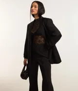 Pantalón de viscosa con corte flare, cintura alta, sin estampa, con frisos delanteros y abertura lateral en el bajo.