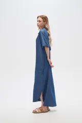 Vestido largo camisero de lyocell azul denim, corte holgado, con cuello camisero, mangas cortas con dobladillo y cierre frontal con botones.