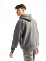 Buzo canguro verde con capucha y bolsillo frontal, de corte oversized.