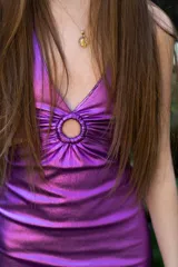 Vestido corto de fiesta color lila metalizado, con escote en V, breteles finos, cut-outs en la cintura y falda ajustada con cordones laterales.