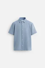 Camisa celeste de corte recto, manga corta y cuello solapa.