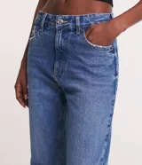 Pantalón de jeans azul de corte slim, tiro alto y cinco bolsillos.