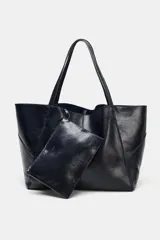 Bolso tipo maxi shopper de piel, color azul marino oscuro, con asas de hombro y pespuntes a tono. Presenta un cierre mediante tiras con botón y un bolsillo interior extraíble.