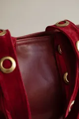 Cartera tote grande de cuero color marrón con asas de cuero con estampado animal print y ojales metálicos dorados.