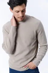 Buzo de punto color beige con textura acanalada y cuello redondo.