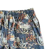 Short de baño azul con estampado floral en tonos blanco, naranja y verde. Tiene elástico en la cintura, cordón ajustable, bolsillos laterales y un bolsillo trasero con botón. Marca Von Braun.