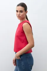 Blusa roja sin mangas, con cuello redondo y sisa drapeada.
