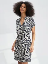 Vestido corto con estampado floral en tonos azul y blanco, con cuello en V, mangas cortas y lazo en la cintura.