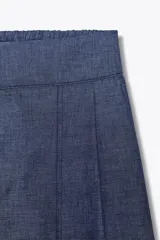 Pantalón azul de tiro alto con pinzas y nervio marcado delantero, cintura elástica en la espalda, pernera ancha y cierre frontal con cremallera, botón interior y ganchos.