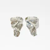 Par de caravanas plateadas con diseño abstracto.