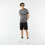 Camiseta negra de manga corta con estampado de hojas de palmera en blanco y gris.