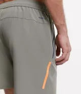 Bermuda deportiva negra sin estampa, con cintura elástica ajustable con cordón, y bolsillo lateral con cierre de cremallera en color contrastante.