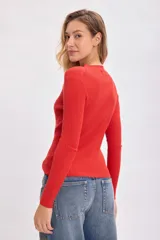 Polera roja de punto de rib con cuello alto y mangas largas.