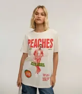 Remera color crudo de algodón con estampado frontal de Justin Bieber y la palabra "Peaches" en rojo.
